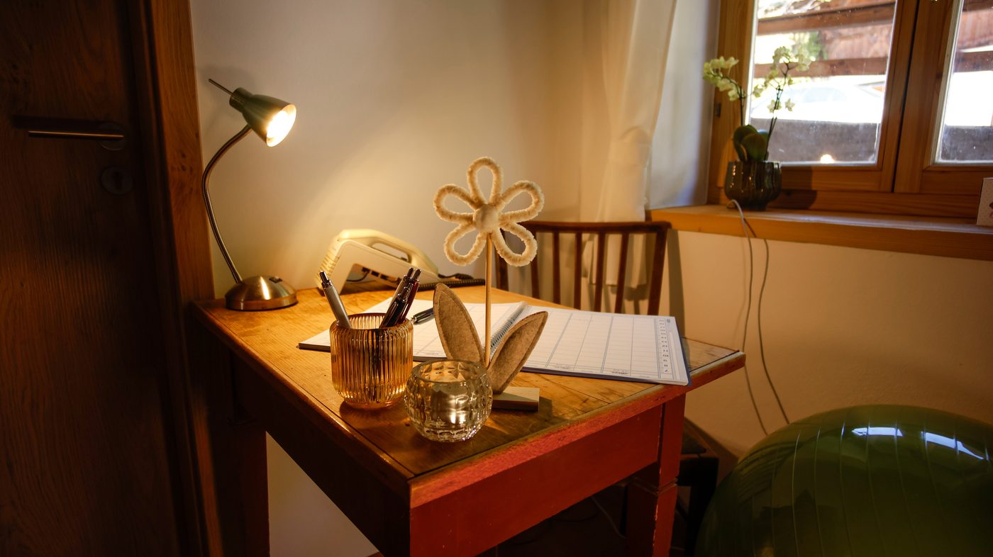 Schreibtisch mit Lampe, Stiften und Filz-Blume